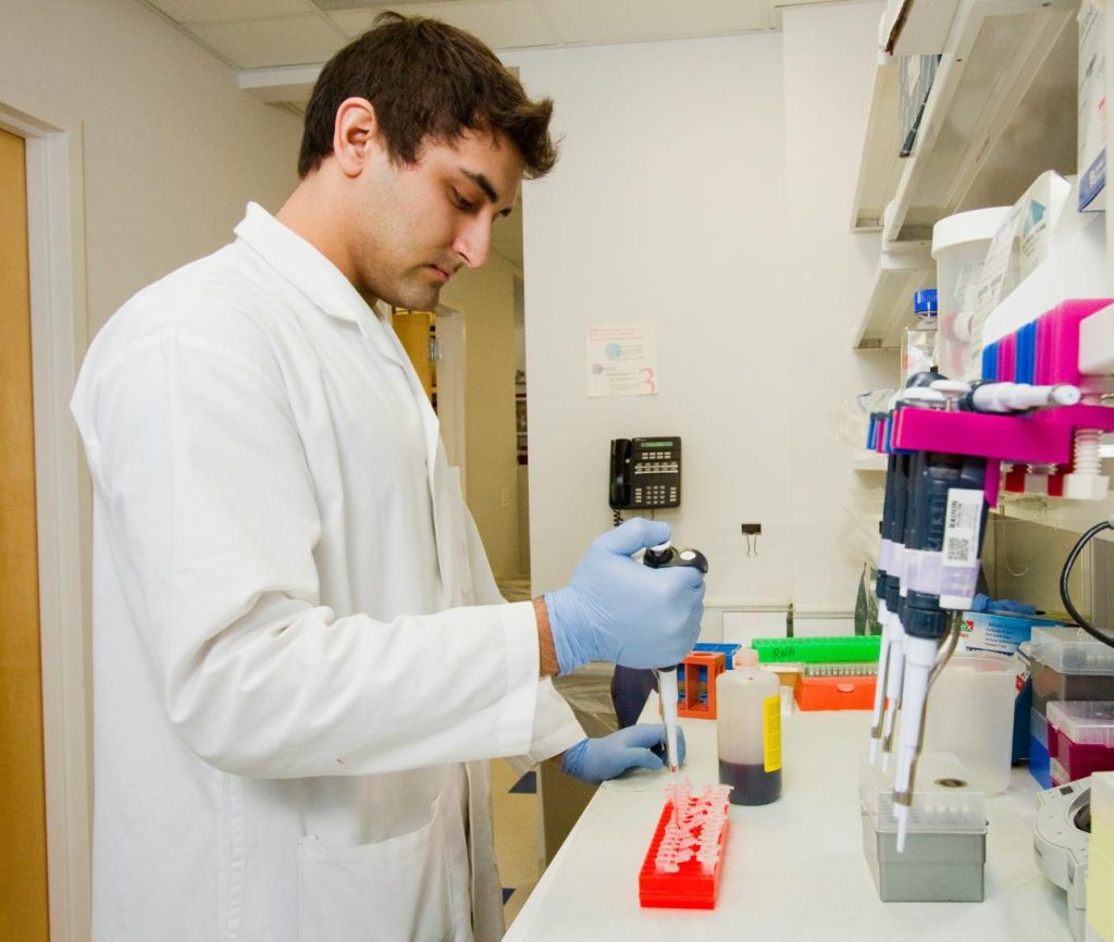 Hombre en laboratorio utilizando pipeta